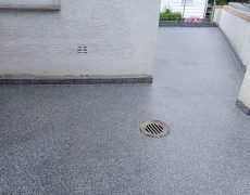 Graumelierter Boden auf auf Balkon mit Bodenablauf.