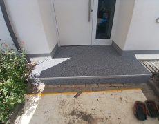 Eine Stufe vor weißer Haustüre.