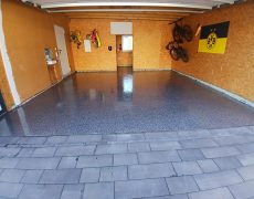 Garagenbodenbeschichtung in Garage mit hellbraunen Wänden und Fahrräder und BVB Flagge an der Wand.